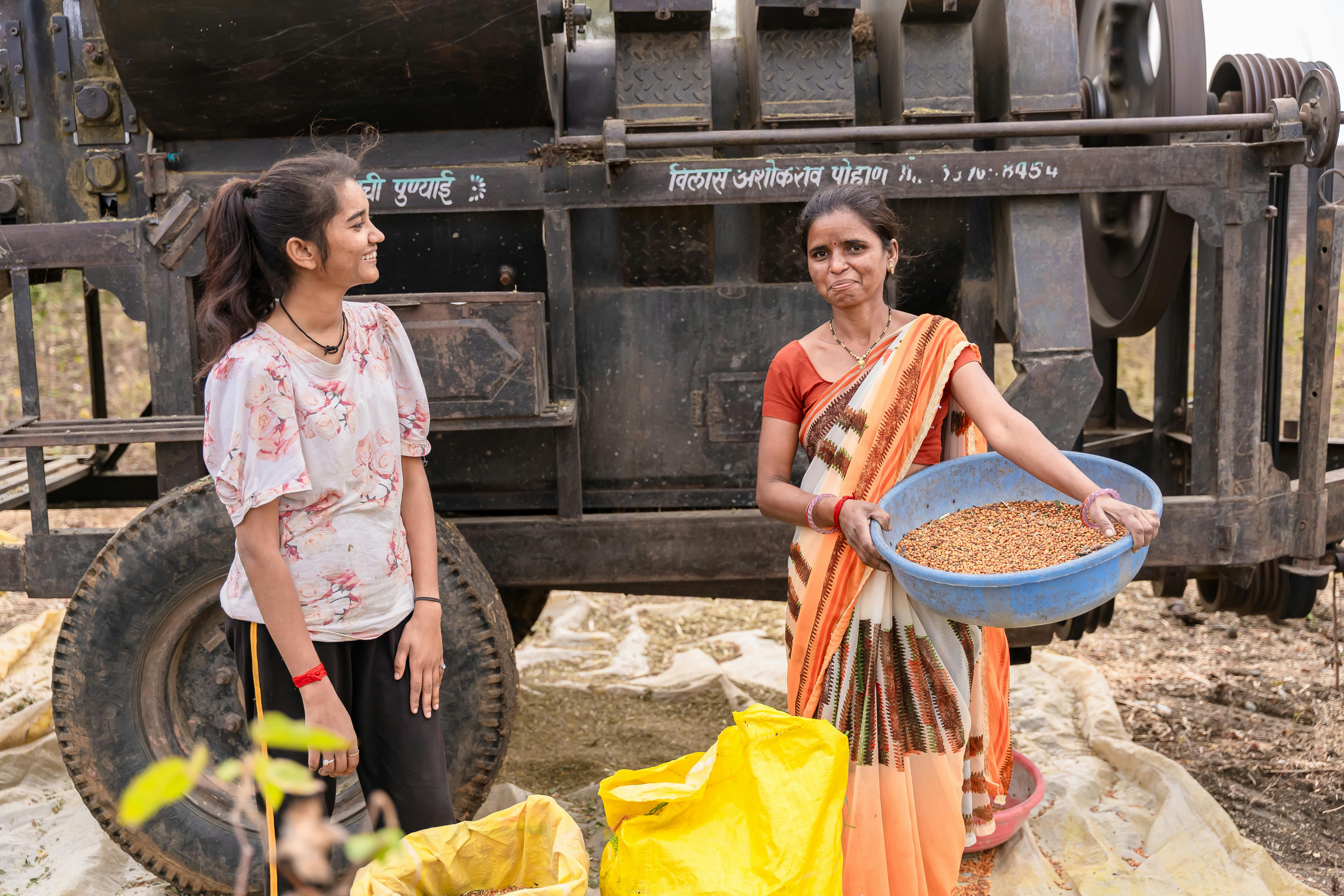 Women processing grains with traditional equipment